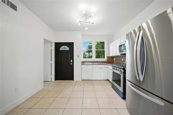 a kitchen with a refrigerator sink and cabinets