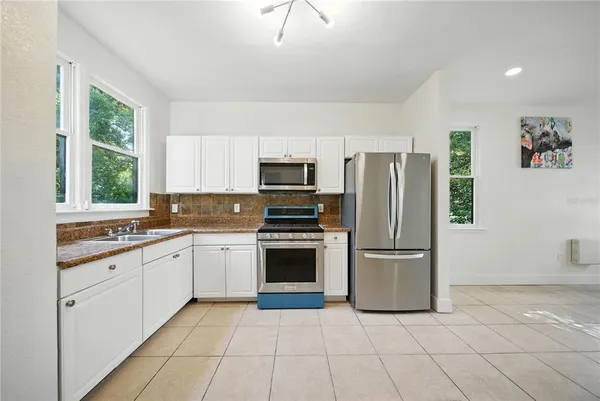a kitchen with stainless steel appliances granite countertop a refrigerator and a stove top oven