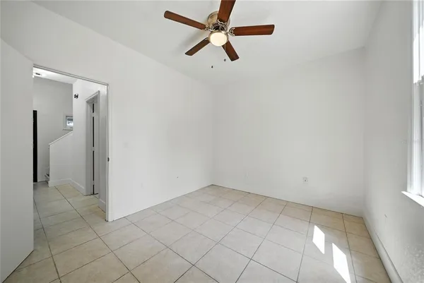 an empty room with chandelier fan