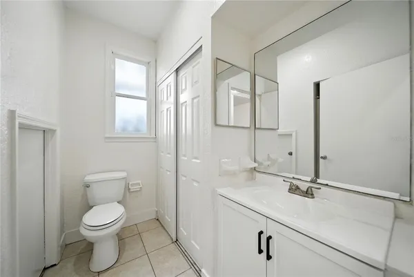 a bathroom with a toilet a sink and mirror