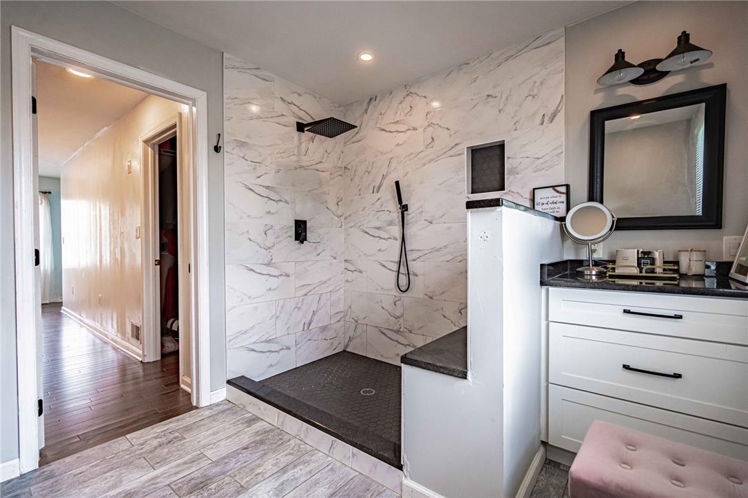 102 Sutton Road Easton, PA 18045 - Photo 44 of 83 An elegant walk-in shower features marble-patterned tile walls and a built-in bench.