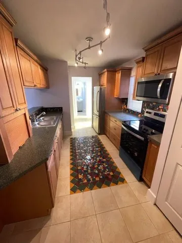 a kitchen with granite countertop a stove and a refrigerator