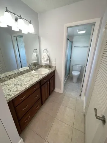 a bathroom with a granite countertop sink and a mirror