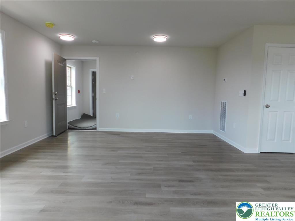 1513 Maple Street, Unit 101 Bethlehem, PA 18017 - Photo 5 of 18 a view of an empty room with wooden floor and cabinet