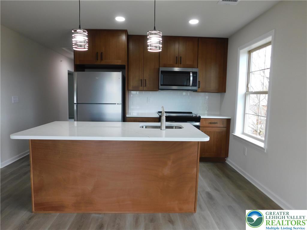 1513 Maple Street, Unit 101 Bethlehem, PA 18017 - Photo 6 of 18 a kitchen with kitchen island a sink stainless steel appliances and window