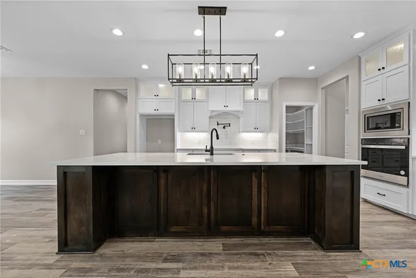 a kitchen with kitchen island granite countertop a wooden cabinets and refrigerator