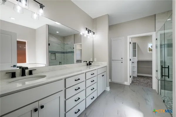 a bathroom with double vanity sink and a mirror