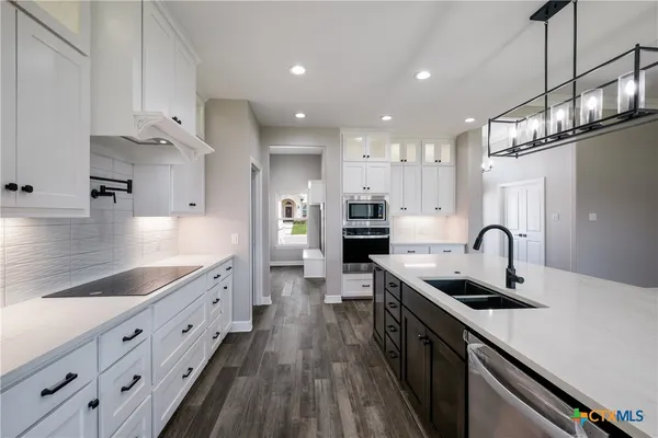 a kitchen with granite countertop a sink stove and cabinets