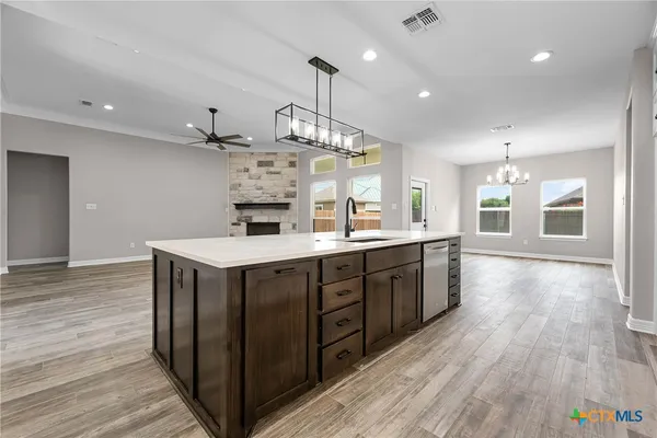 a large kitchen with stainless steel appliances granite countertop a lot of counter space and wooden floors