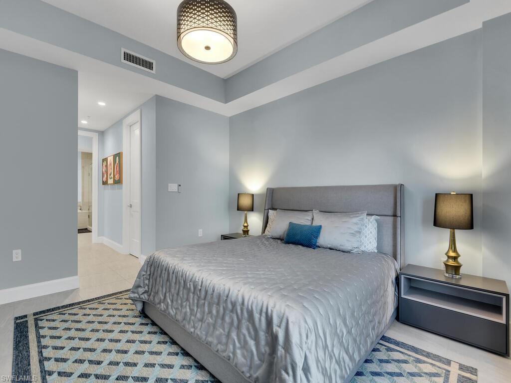1111 Central Avenue, Unit 216 Naples, FL 34102 - Photo 16 of 50 a bedroom with a bed and a lamp