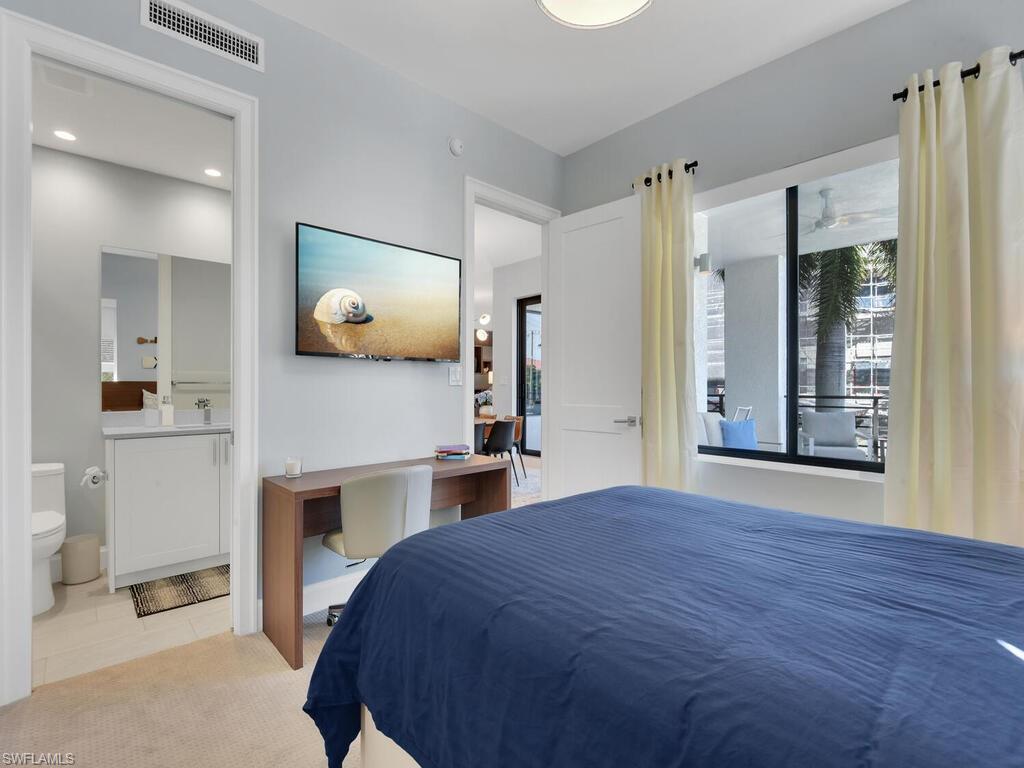 1111 Central Avenue, Unit 216 Naples, FL 34102 - Photo 21 of 50 a bedroom with a bed and a flat screen tv