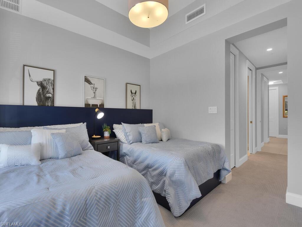 1111 Central Avenue, Unit 216 Naples, FL 34102 - Photo 24 of 50 a bedroom with two beds and painting on the wall