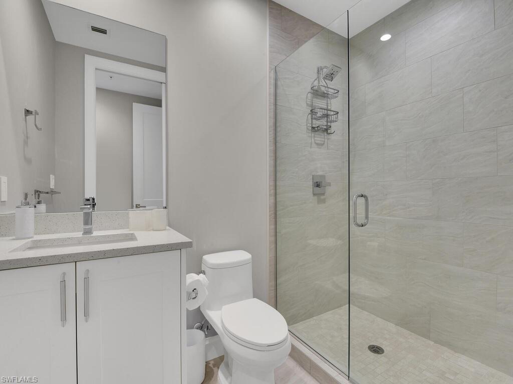 1111 Central Avenue, Unit 216 Naples, FL 34102 - Photo 26 of 50 a bathroom with a sink a toilet and shower