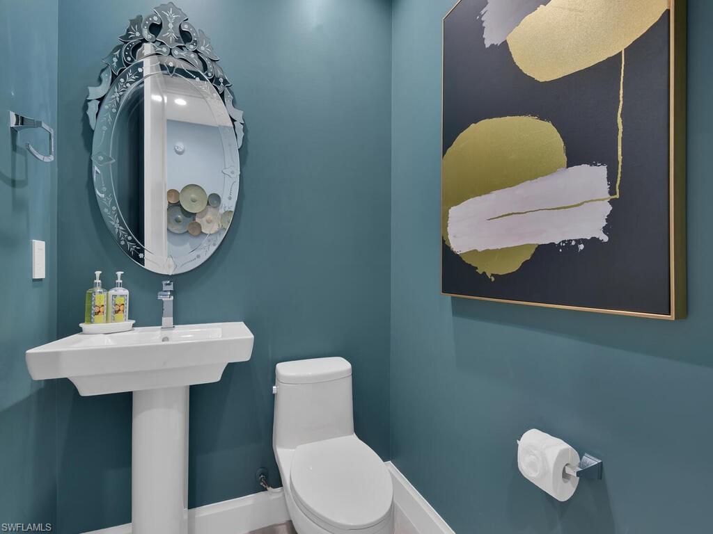 1111 Central Avenue, Unit 216 Naples, FL 34102 - Photo 28 of 50 a bathroom with a toilet sink and mirror