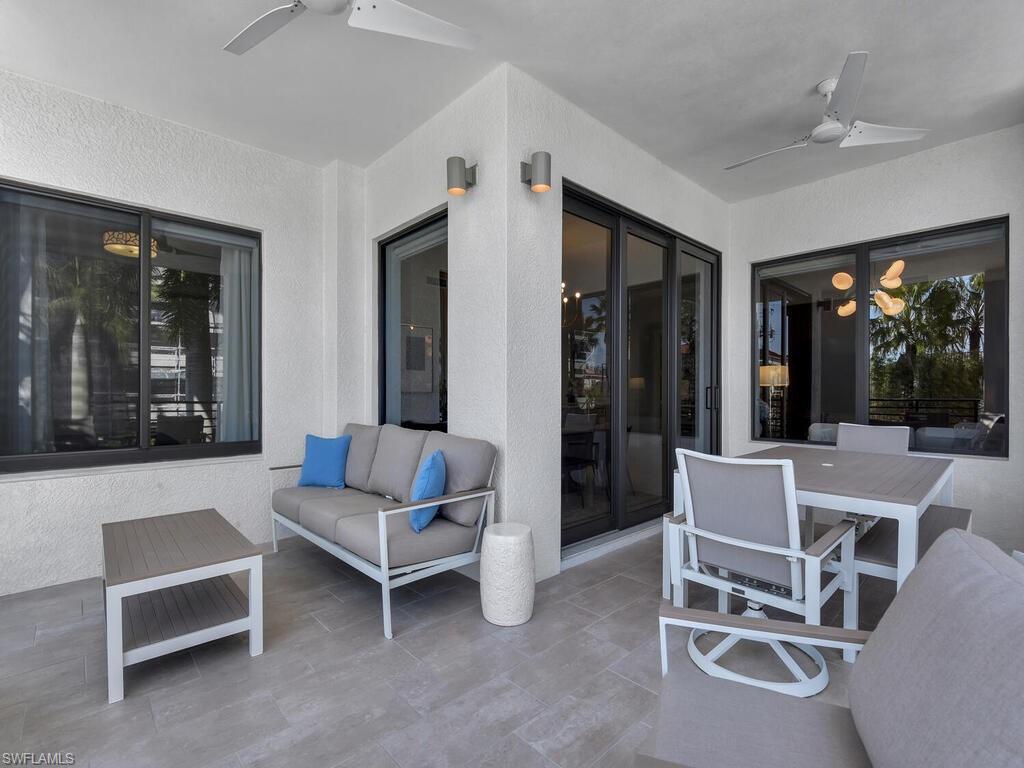 1111 Central Avenue, Unit 216 Naples, FL 34102 - Photo 29 of 50 a living room with furniture a large window and table