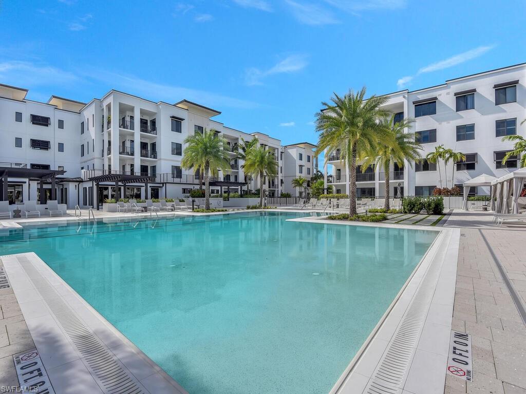 1111 Central Avenue, Unit 216 Naples, FL 34102 - Photo 39 of 50 a view of swimming pool with outdoor seating and lake view