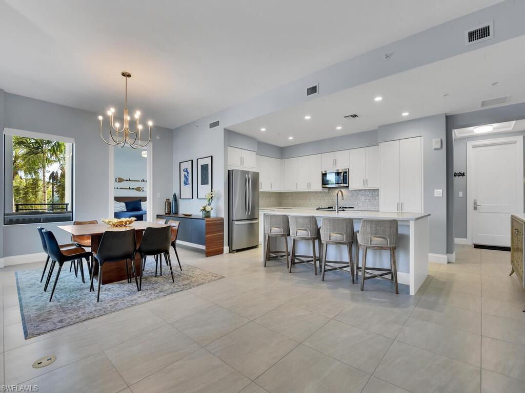 1111 Central Avenue, Unit 216 Naples, FL 34102 - Photo 6 of 50 a view of a dining room with furniture and chandelier