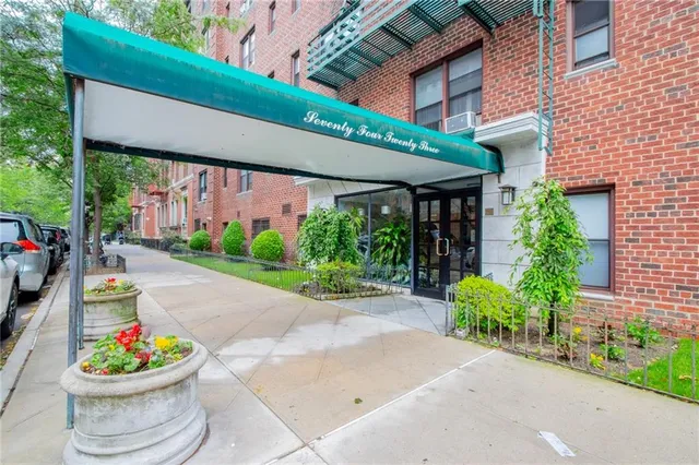 a front view of a building with a garden and plants