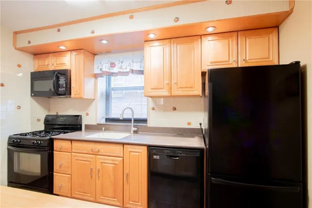 a kitchen with stainless steel appliances granite countertop white cabinets and a refrigerator
