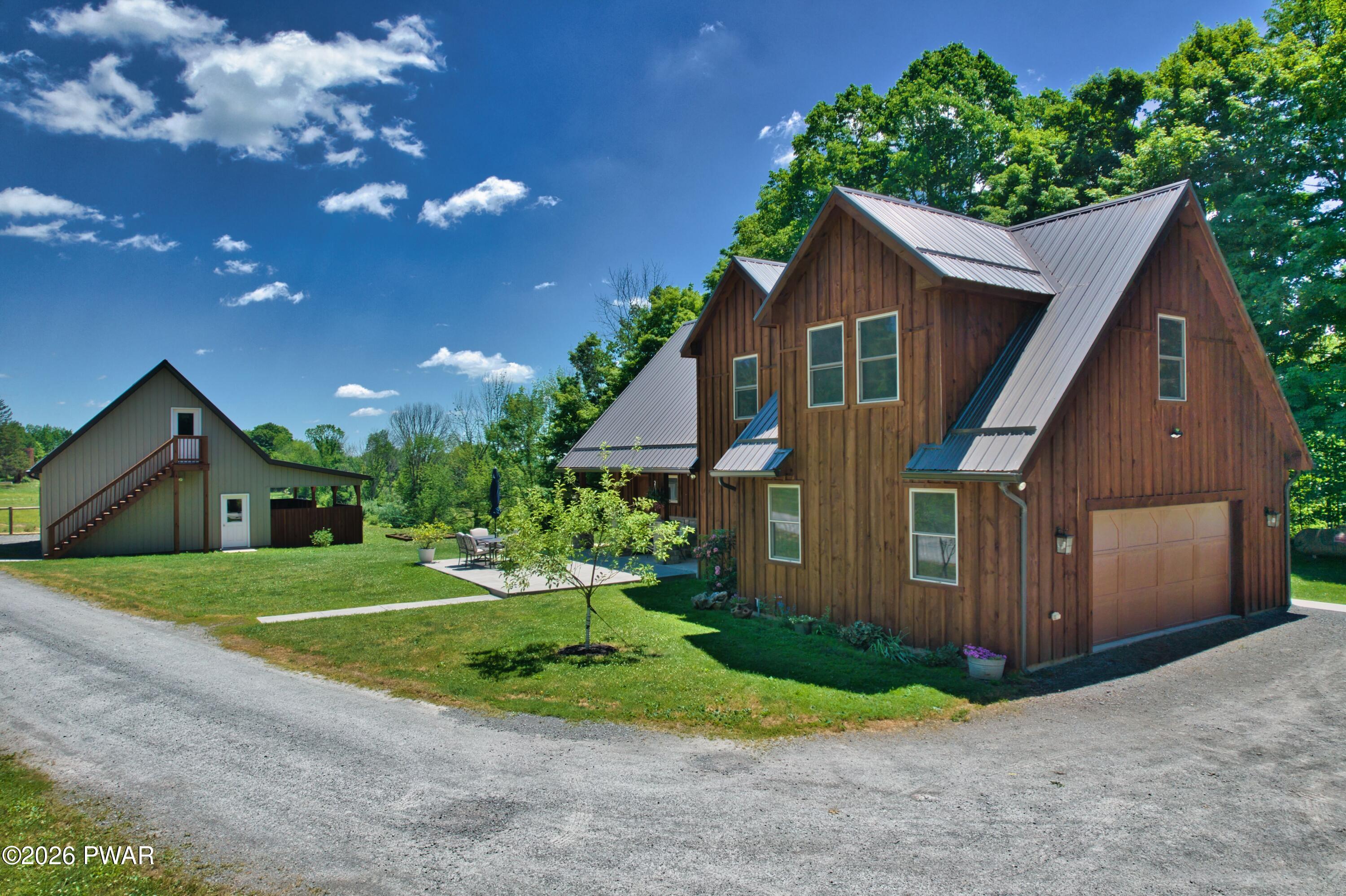 149 Sheards Road Milanville, PA 18443 - Photo 11 of 57 a front view of a house with a yard and garage