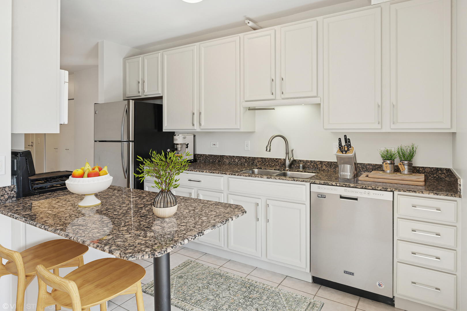 630 North State Street, Unit 1406 Chicago, IL 60654 - Photo 9 of 18 a kitchen with granite countertop white cabinets sink and stove