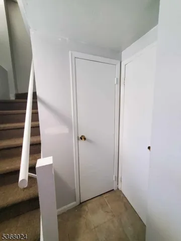 an view of an empty room with wooden floor and stairs