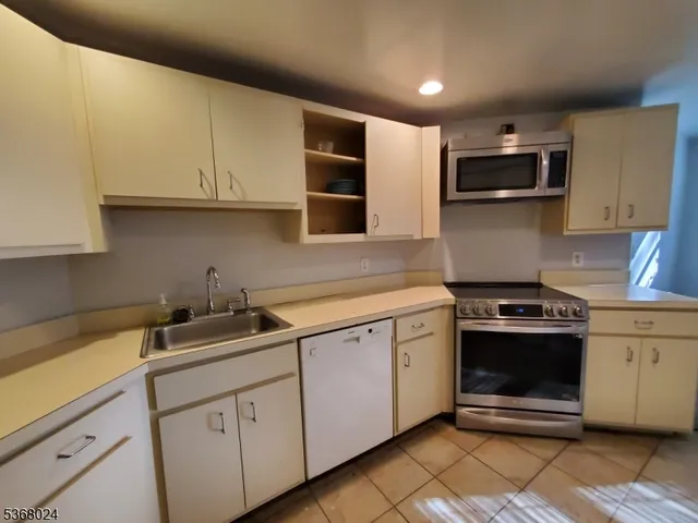 a kitchen with stainless steel appliances granite countertop a sink and a stove