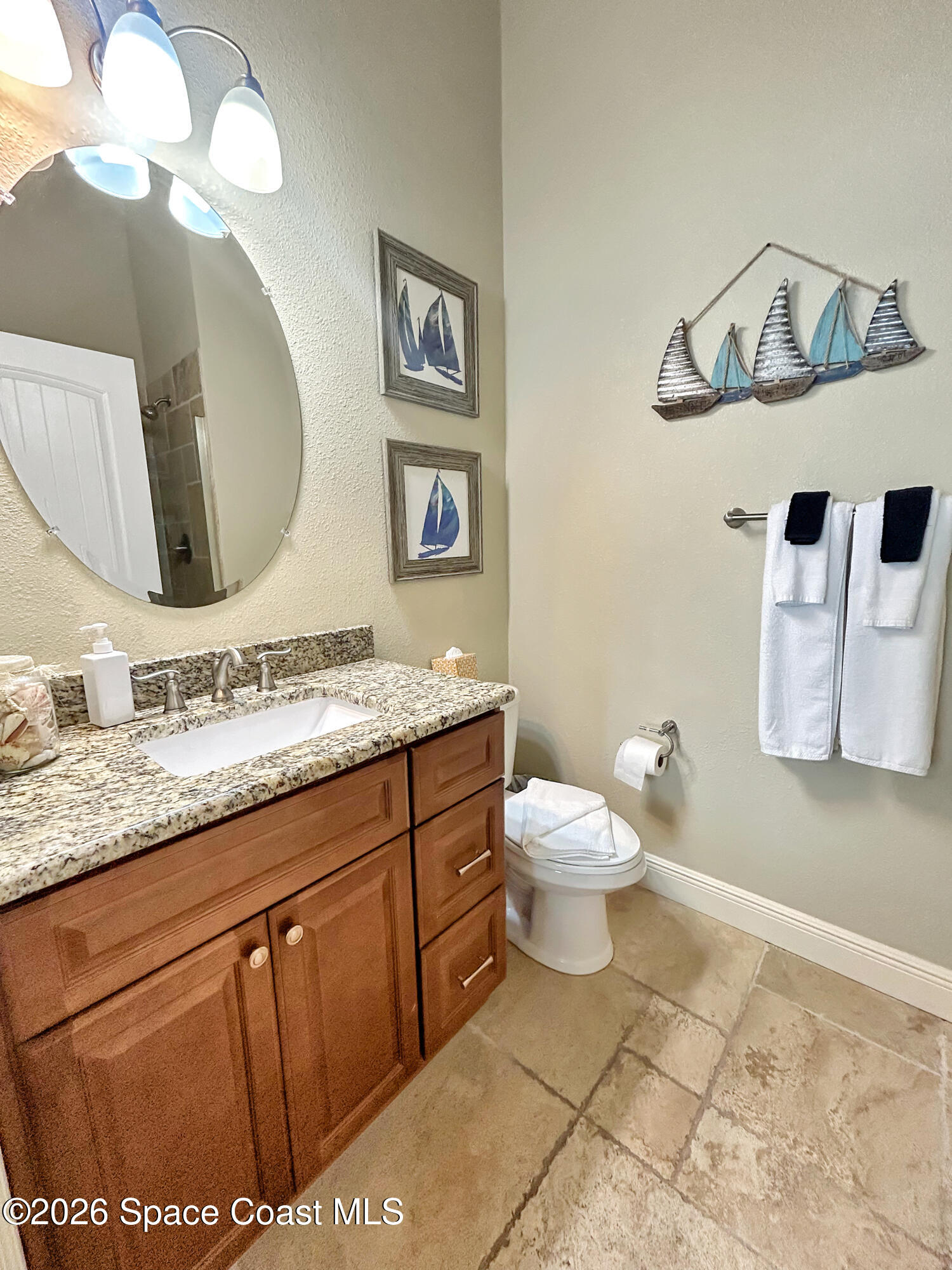 2709 Cutlass Point Lane, Unit 103 Merritt Island, FL 32953 - Photo 13 of 31 a bathroom with a granite countertop toilet sink and mirror