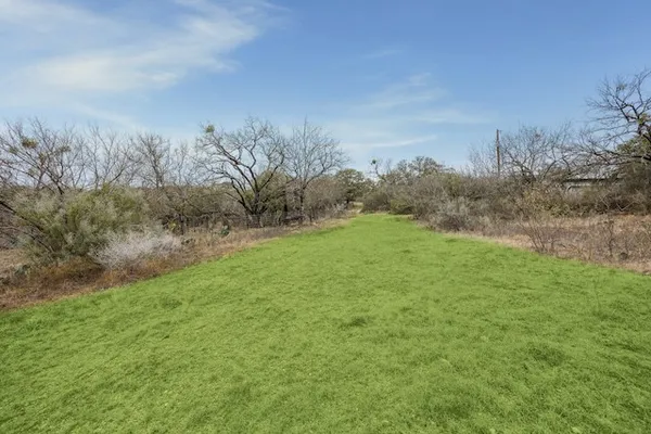 a view of a field with trees in background