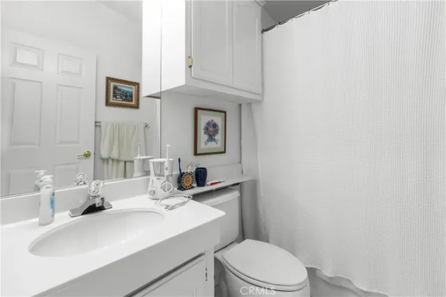 a bathroom with a sink a toilet and mirror