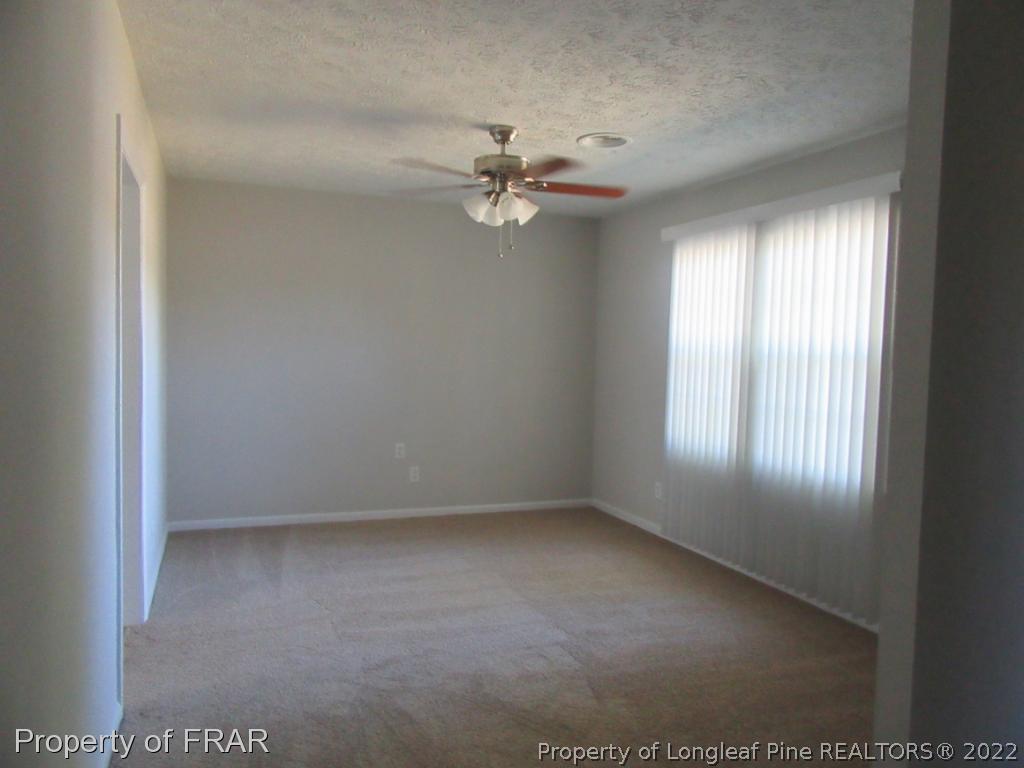 5947 Spinner Road Hope Mills, NC 28348 - Photo 11 of 31 an empty room with windows and ceiling fan