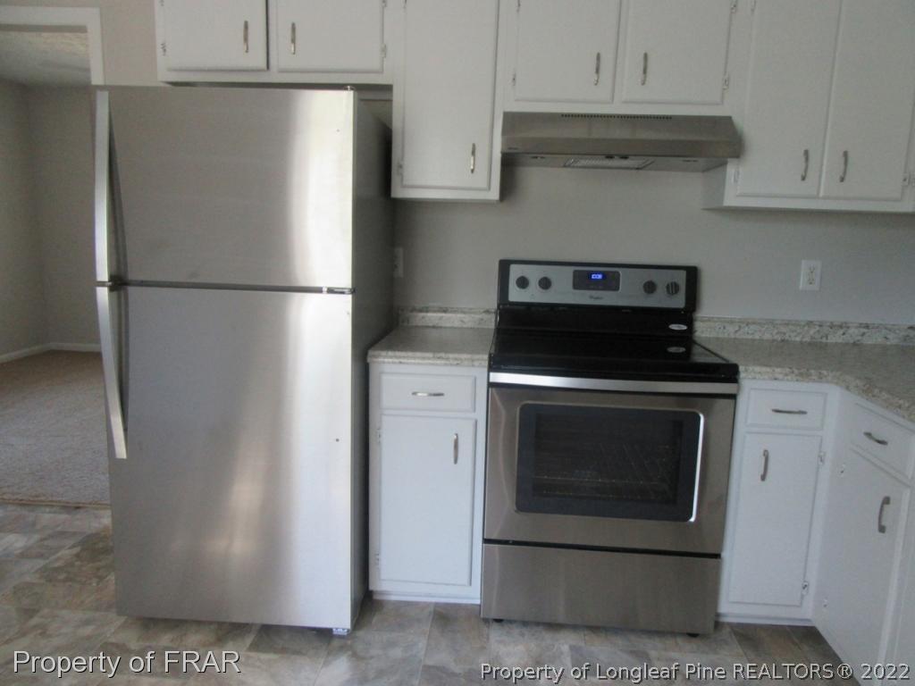 5947 Spinner Road Hope Mills, NC 28348 - Photo 13 of 31 a kitchen with refrigerator and cabinets