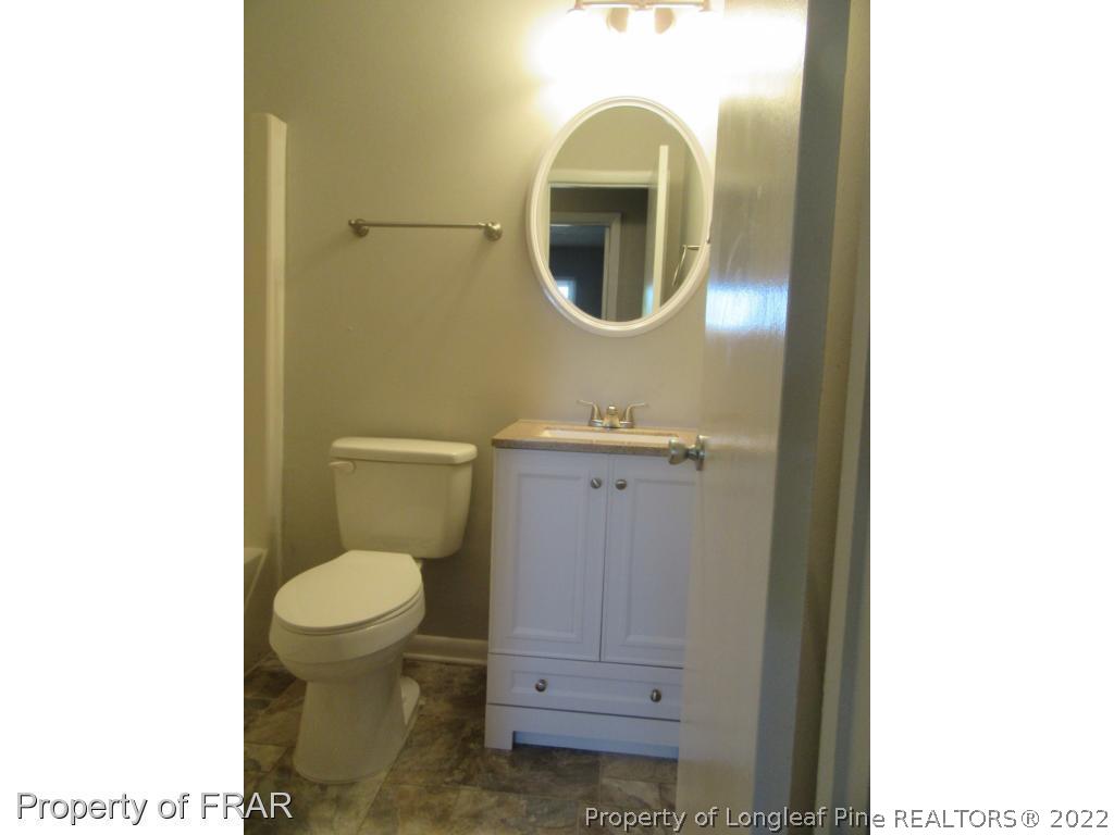 5947 Spinner Road Hope Mills, NC 28348 - Photo 17 of 31 a bathroom with a toilet a sink and a mirror
