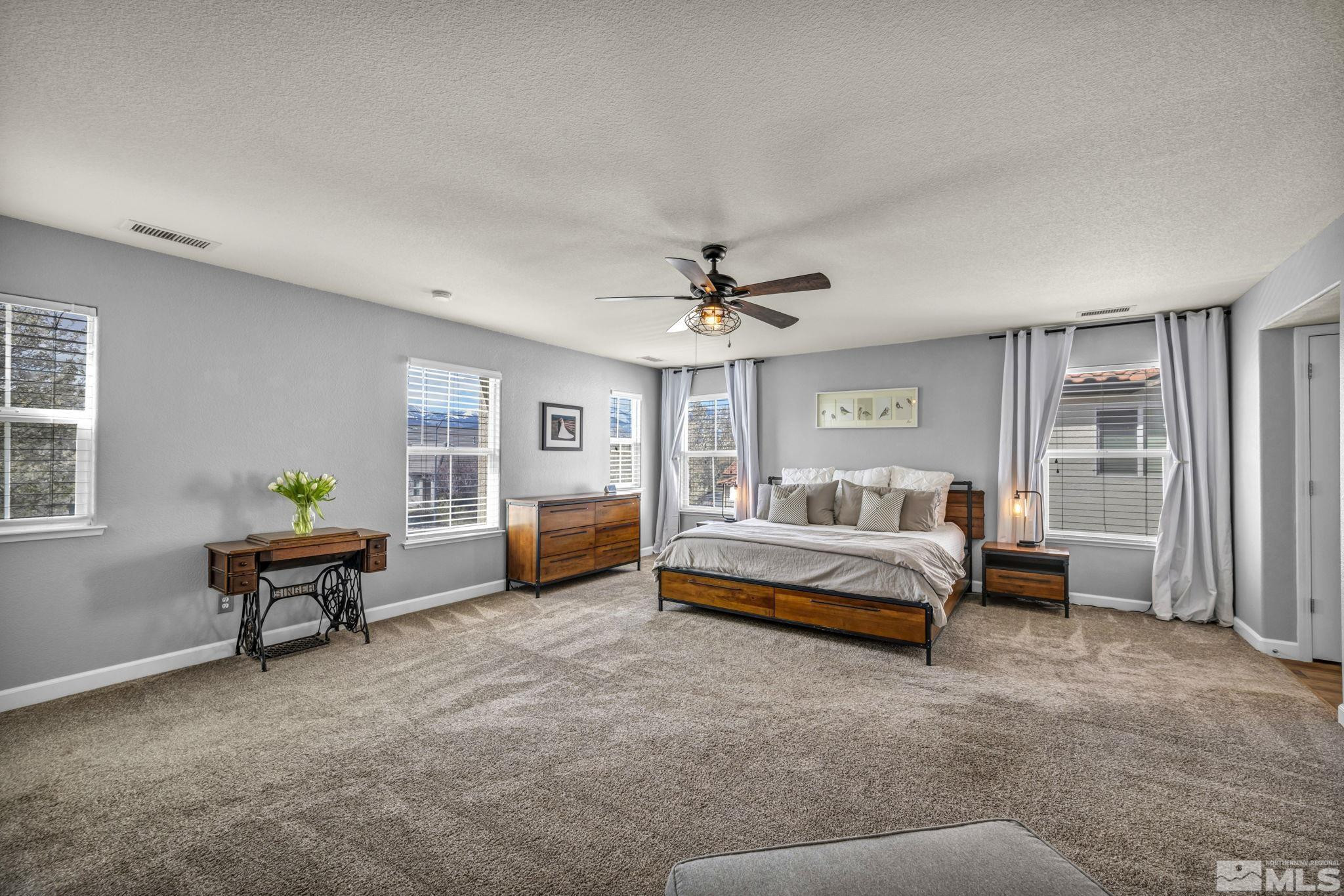485 Sondrio Court Reno, NV 89521 - Photo 18 of 40 a spacious bedroom with a bed and a chandelier