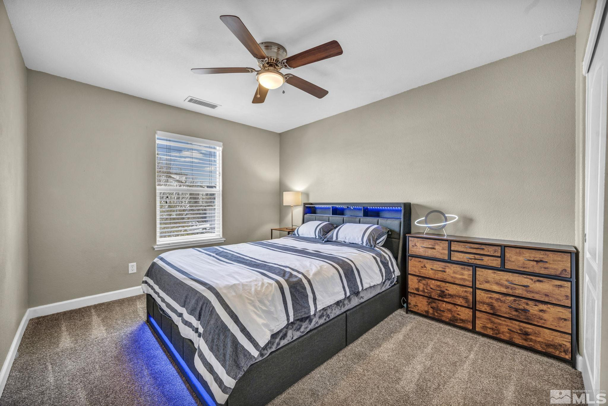 485 Sondrio Court Reno, NV 89521 - Photo 23 of 40 a bedroom with a bed and a chandelier