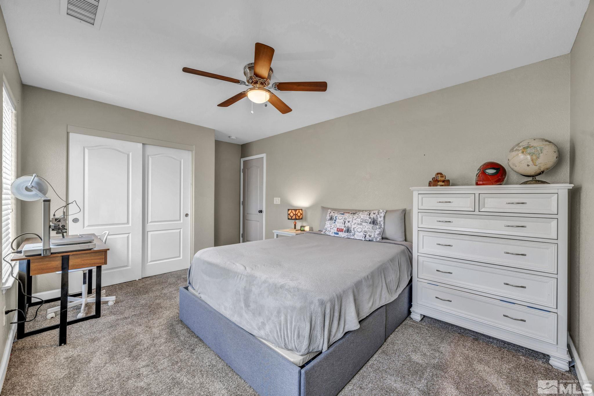 485 Sondrio Court Reno, NV 89521 - Photo 26 of 40 a bedroom with a bed and a chandelier