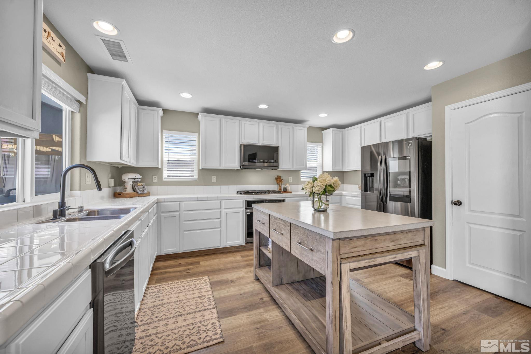 485 Sondrio Court Reno, NV 89521 - Photo 10 of 40 a kitchen with white cabinets and stainless steel appliances