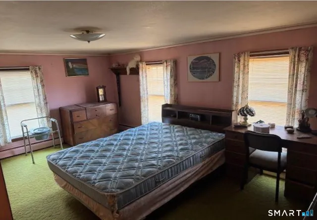 a bed sitting in a bedroom next to a window