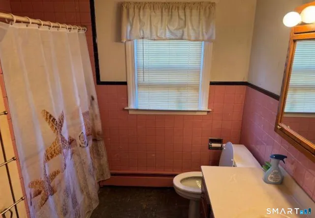 a bathroom with a sink a toilet and a shower curtain