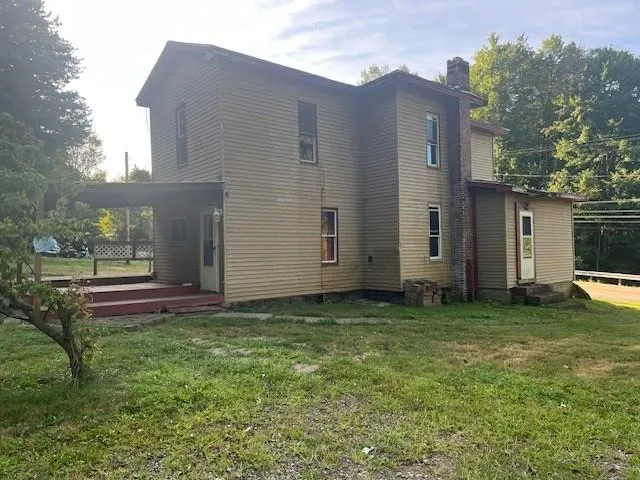 a backyard of a house with table and chairs