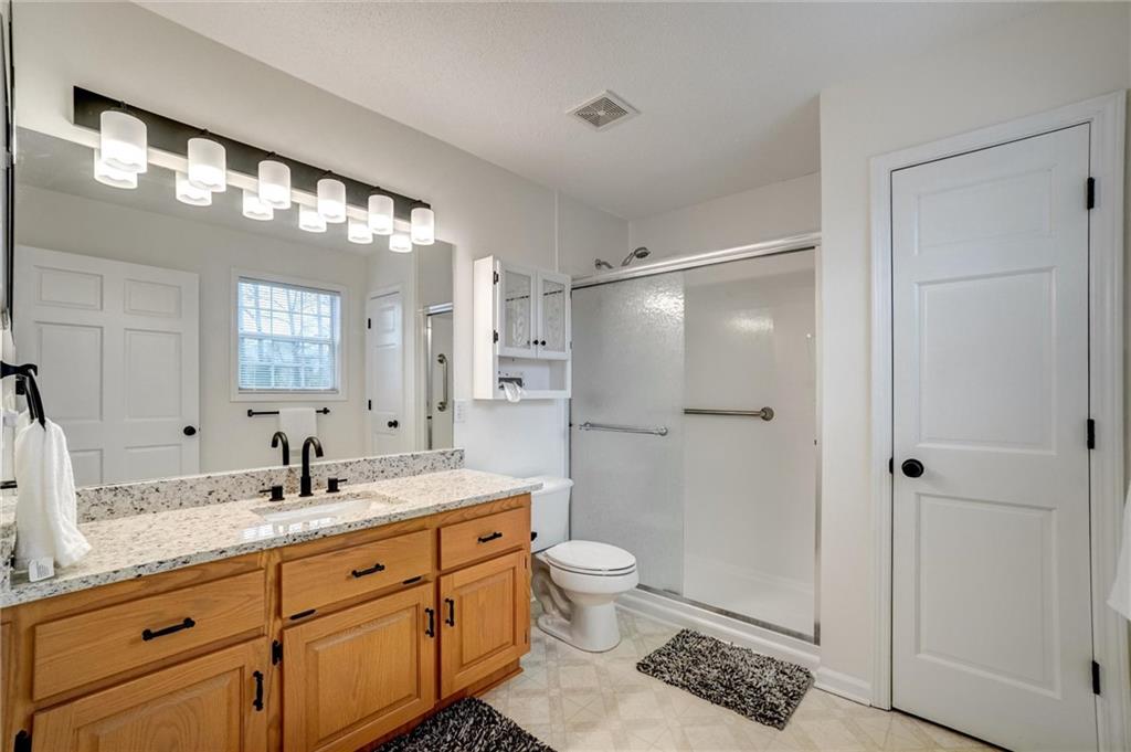 701 Longview Street Canton, GA 30114 - Photo 15 of 18 a bathroom with a double vanity sink toilet mirror and shower