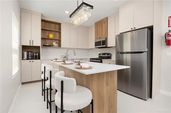 a kitchen with stainless steel appliances a table chairs and a refrigerator