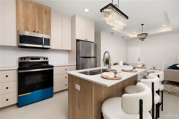 a kitchen with stainless steel appliances granite countertop a sink a stove a refrigerator and cabinets