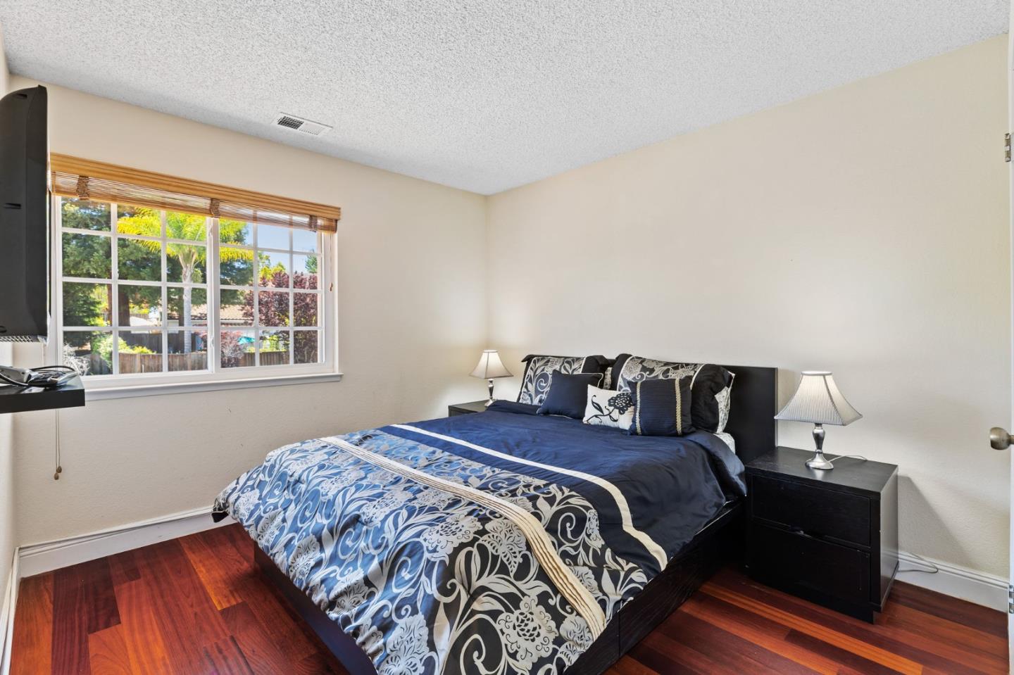 43643 Skye Road Fremont, CA 94539 - Photo 12 of 16 a bedroom with a bed and wooden floor