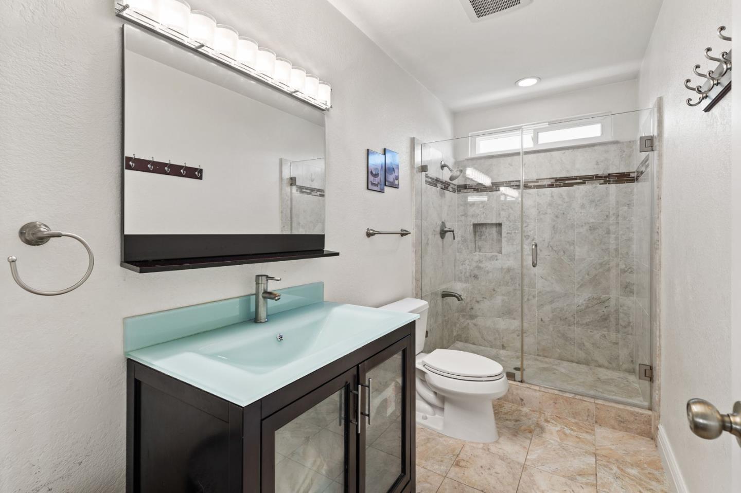 43643 Skye Road Fremont, CA 94539 - Photo 14 of 16 a bathroom with a sink a toilet and shower