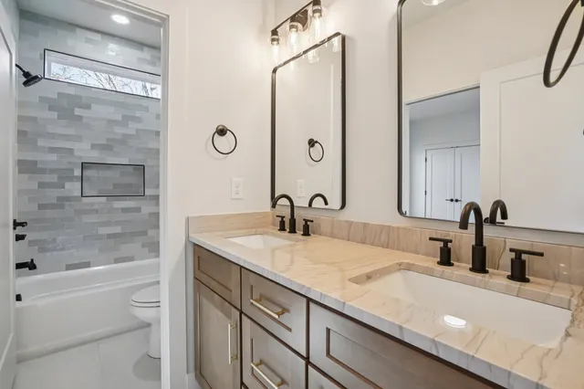 a bathroom with a granite countertop sink a toilet and shower