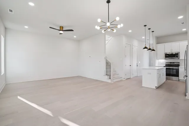 a view of an empty room with a kitchen