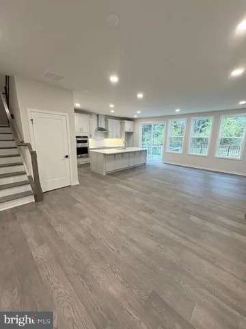 a view of a kitchen with wooden floor and a window