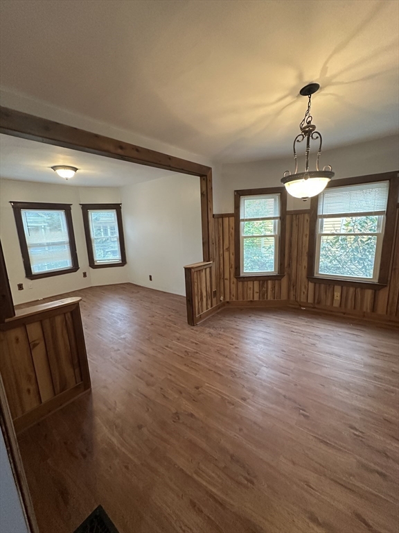 a view of an empty room with window and wooden floor