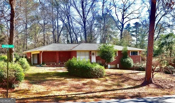 a view of a yard in front of a house with large tree